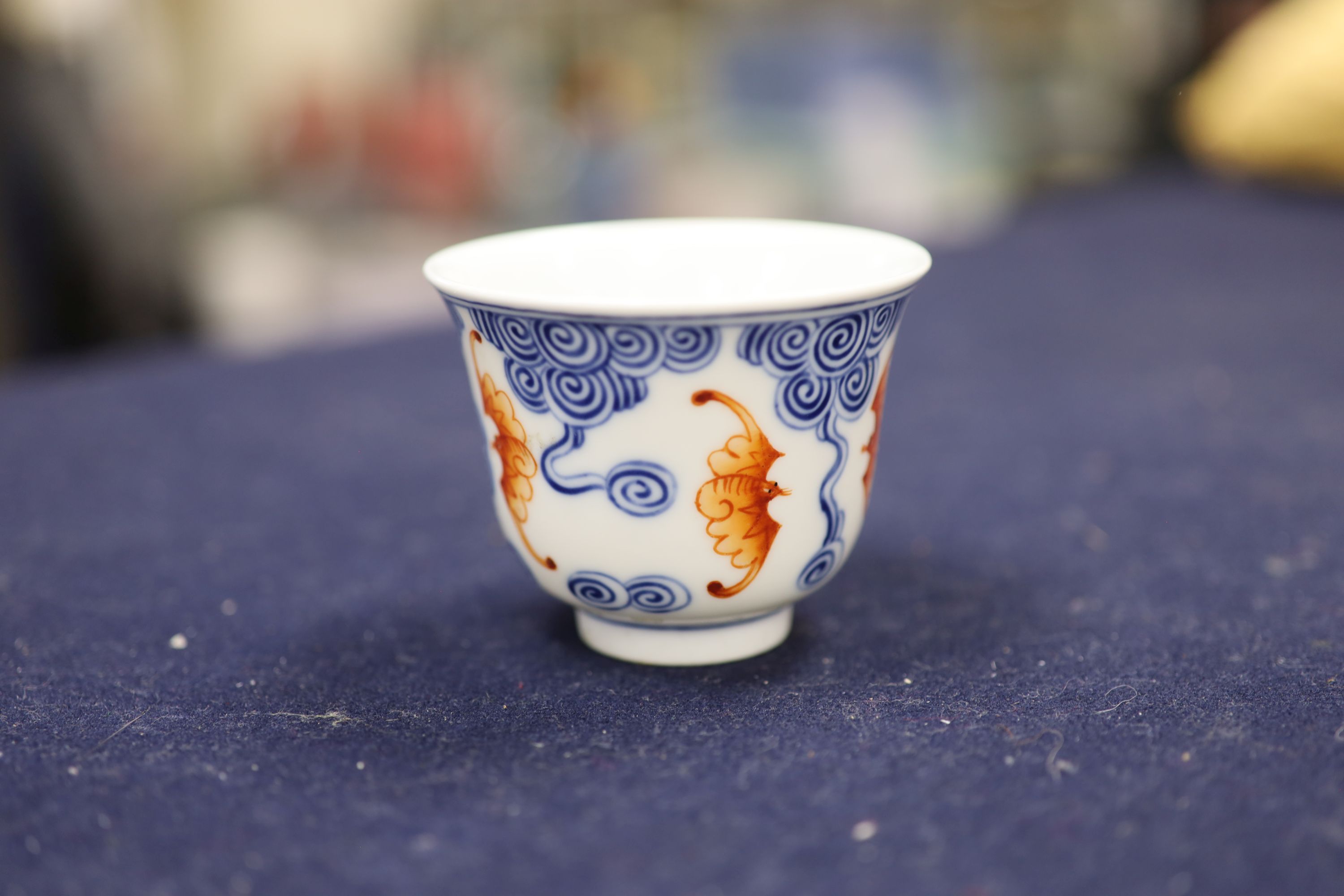 A Chinese underglaze blue and iron red 'bat' cup, height 6cm